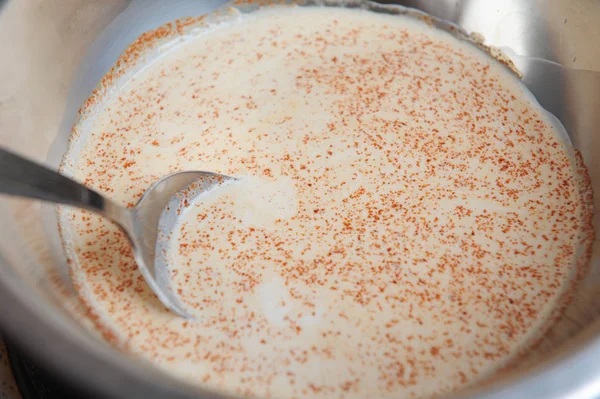 牛奶或奶油与红辣椒的混合物。钢碗、 勺子。烹调过程中 — 图库照片