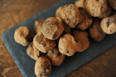 Çikolata truffles kakao serpilir. Ahşap arka plan kayrak tahtada. Yakın çekim, doku