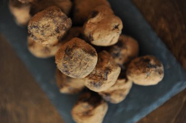 Çikolata truffles kakao serpilir. Ahşap arka plan kayrak tahtada. Yakın çekim, doku