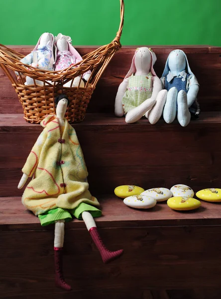 Easter composition. Soft toys of rabbits handmade with eggs in a wicker basket. Detail of decor. Green background — Stock Photo, Image