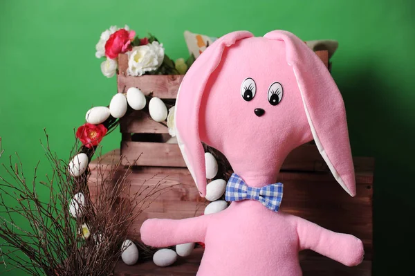 Large pink soft bunny in plaid bow tie with Easter decoration — Stock Photo, Image