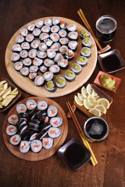 Ev yapımı suşi rulo. Sopa, limon, soya sosu, wasabi koyu kahverengi ahşap bir masa üzerinde servis edilir