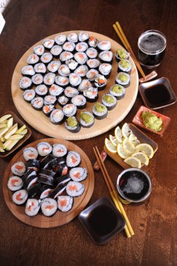 Ev yapımı suşi rulo. Sopa, limon, soya sosu, wasabi koyu kahverengi ahşap bir masa üzerinde servis edilir