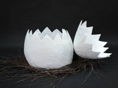 Büyük kağıt mache yumurta bir yuvaya şube siyah bir zemin üzerine iki kısımdan ortaya olduğunu