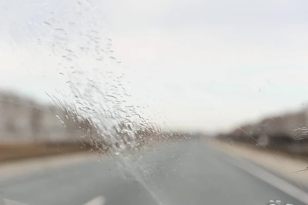 Потік води на вітрове скло. Вид на дорогу — стокове фото