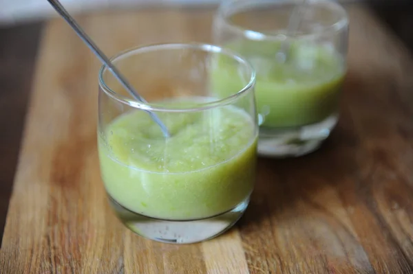 Green smoothies in a glass, close-up. Wooden texture — Stock Photo, Image