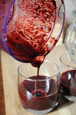 Berry smoothies blender kabı üzerinden bardaklarda şişelenmiş