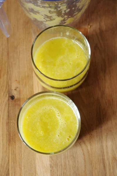Yellow smoothies in two glasses top view — Stock Photo, Image