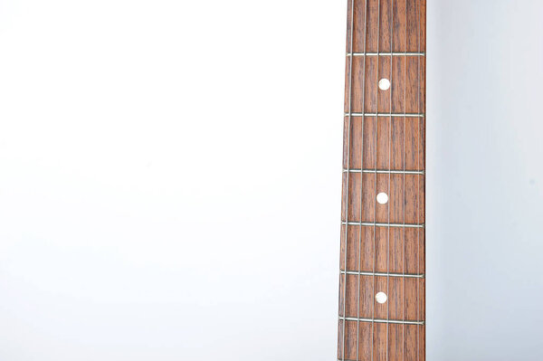 Guitar neck with strings on white background, free space for design