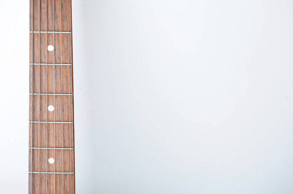 Guitar neck with strings on white background, free space for design
