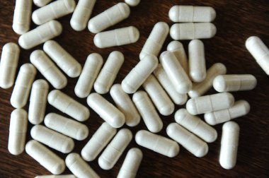 Plaser kapsül tablet ahşap arka plan üzerinde kapat