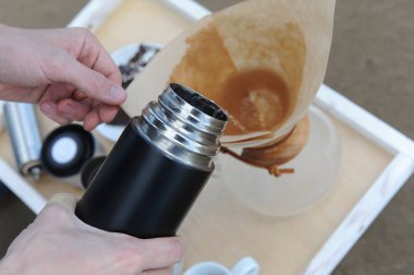 Alternatif bir tepsi kum plajındaki kahve bira için aksesuarlar. Filtre kahve termosu dökülür