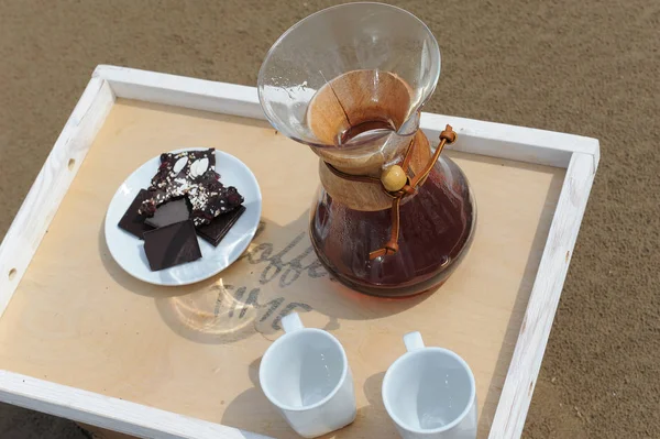 Accessories for alternative brewing coffee on a tray on the rsandy beach