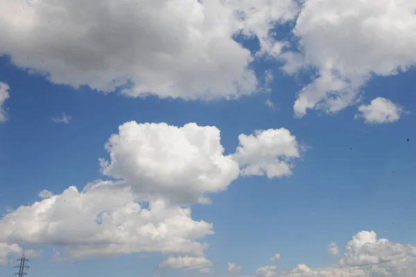 Блакитне яскраве небо з пухнастими кумульськими хмарами — стокове фото