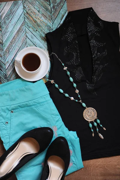 Giysi ve aksesuarları şık düzeni. Turkuaz pantolon, akşam üst, siyah ayakkabılar, tespih ve bir fincan kahve — Stok fotoğraf