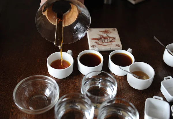 The process of coffee cupping. Coffee is poured into tasting cups — Stock Photo, Image