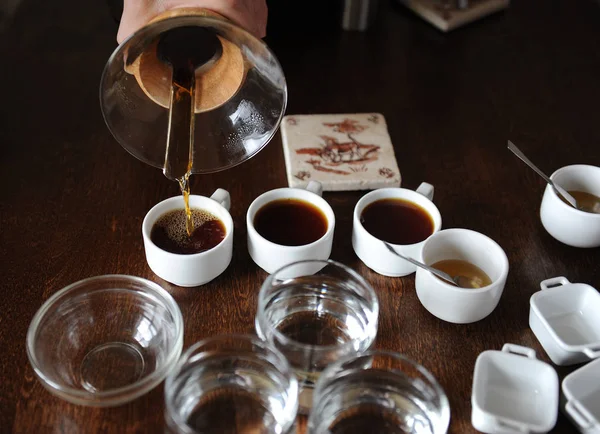 Процесс чашечки кофе. Кофе наливают в дегустационные чашки — стоковое фото