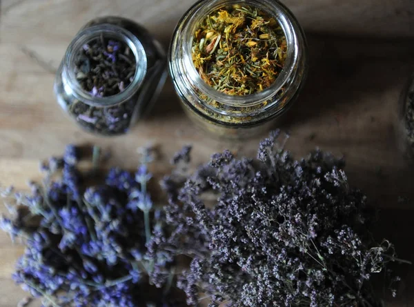 Подготовка травяных чаев и сушеных цветов на деревянной доске — стоковое фото