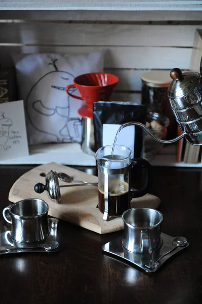 The process of brewing coffee. Pour water from the drip maker into the french press. Pack with white label
