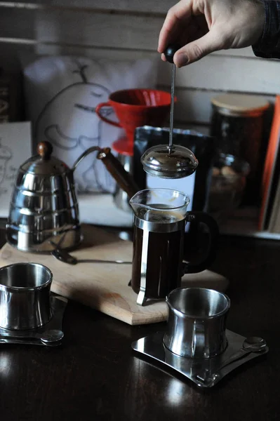 The process of brewing coffee. Barista covers the french press with a lid. Pack with white label — Stock Photo, Image