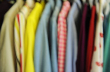 Arka plan bulanık doku renkli gömlek ve bluz bir askı üzerinde bir satırdan