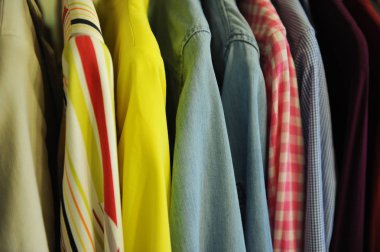 Arka plan doku renkli gömlek ve bluz bir askı üzerinde bir satırdan