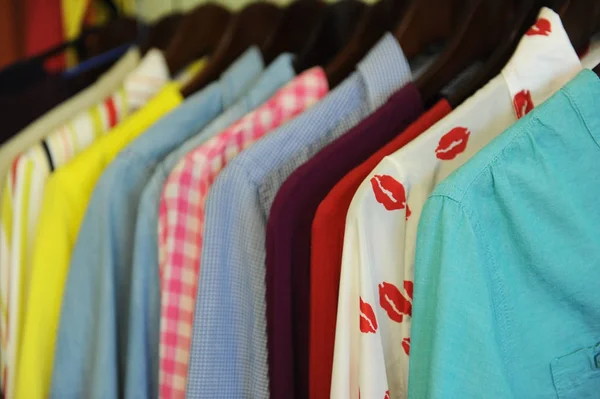 Textura de fondo de una fila de camisas y blusas de colores en una percha — Foto de Stock