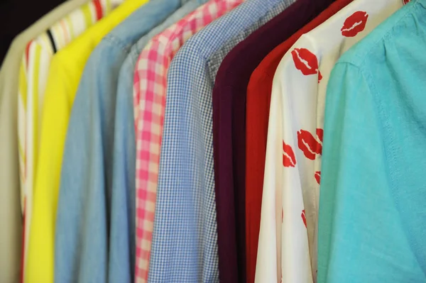 Textura de fondo de una fila de camisas y blusas de colores en una percha — Foto de Stock