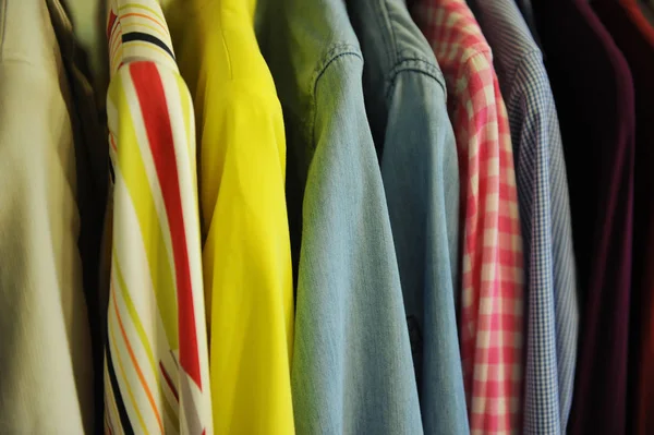 Arka plan doku renkli gömlek ve bluz bir askı üzerinde bir satırdan