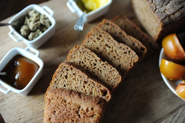 Il pane azzimo fresco fatto in casa sul lievito viene affettato su una tavola di legno. Servizio di prima colazione — Foto Stock