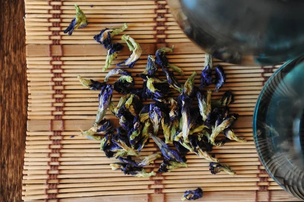 Die Blüten des thailändischen blauen Tees Anchan sind in Großaufnahme auf einer Bambusmatte verstreut — Stockfoto
