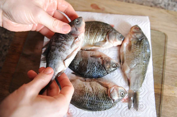 Raw fresh fish whole on cut board. Carp in the hands of chef close-up — Stock Photo, Image