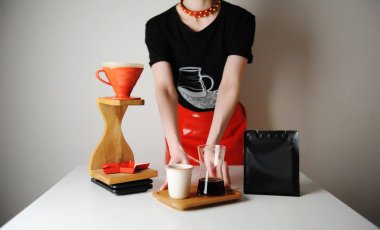 Son moda barista kızı filtre kahve servis ediyor. Odun damlatma istasyonu. Kırmızı deri etek, siyah tişört. Tasarım için yer