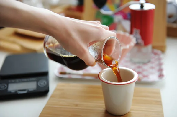 Handbrauen Stillleben. Filterkaffee aus Glaskanne in Tasse gießen. Bambusbrett. Ästhetik der dritten Welle — Stockfoto