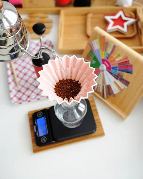 Fabricação de cerveja manual alternativa. Verter água no café em gotejador de origami de cerâmica rosa com filtro de onda de papel. Vista superior — Fotografia de Stock