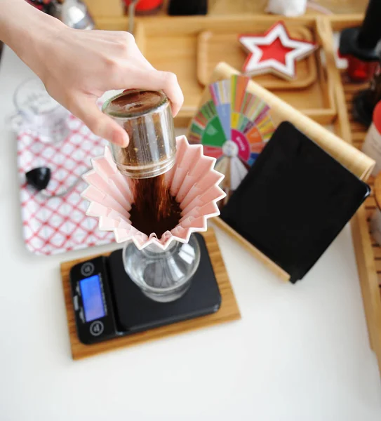 Cervejaria alternativa ainda vida. Despejar café moído na hora em gotejador de origami de cerâmica rosa com filtro de onda de papel . — Fotografia de Stock