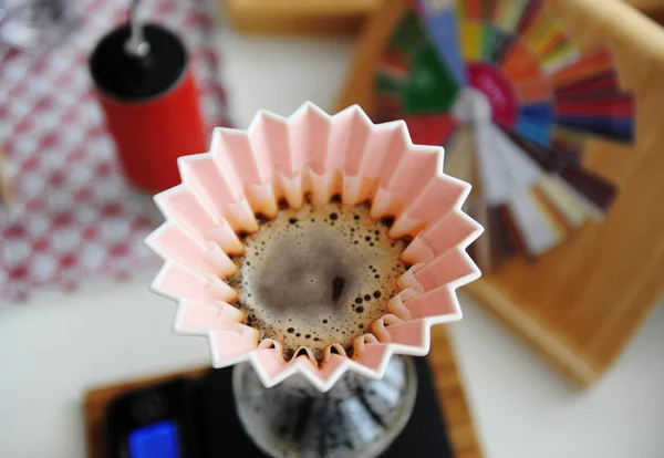 Cervecería manual alternativa. Café en gotero de origami rosa con filtro de onda de papel. Vista superior, primer plano — Foto de Stock