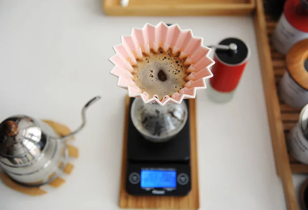 Alternative manual brewing. Pink origami dripper with paper wave filter on decanter on electronic scale. Top view — Stock Photo, Image