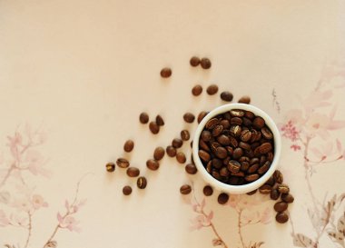 China specialty coffee concept. Roasted bean in white cup and on traditional chinese pattern background. Top view clipart
