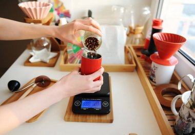Alternatif hayat kaynıyor. Kahve çekirdeklerini elektronik ölçekte kırmızı kahve öğütücüsüne döküyorum. Üçüncü dalga uzmanlık alanı estetik konsepti