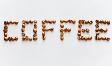Beyaz arka planda altın inci kahve çekirdeklerinden yapılmış Harfli Kahve. Pahalı lüks kahve konsepti.