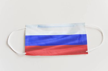 Rusya bayrağı taşıyan koruyucu tıbbi maske. Devlet sınırlarının kapatılması ve pandemik denetimin kavramsal sembolü