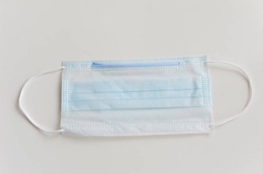 Koruyucu tek kullanımlık tıbbi maske, beyaz arka planda izole edilmiş.