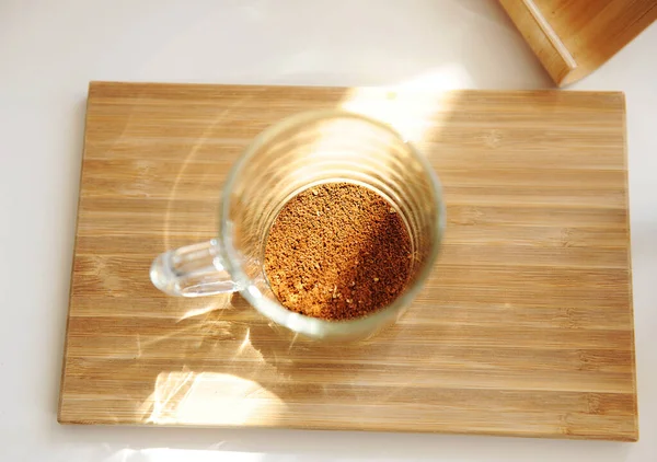 Brassage de café dans une tasse. Café fraîchement moulu dans une tasse de verre vue de dessus — Photo