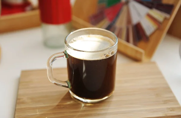 Şeffaf cam bardakta yeni demlenmiş koyu kahve. Elle öğütücü ve tat alma çarkı. Sabah güneşleri — Stok fotoğraf