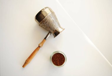 Beyaz arka plan görünümlü, öğütülmüş kahve ile Cezve kavanozu