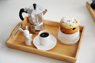 Tahta bambu tepside servis edilen kahve ve kek. Kahve makinası moka pot, beyaz tabaklar. Beyaz arkaplan