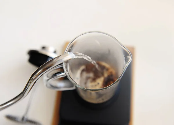 Brewing coffee in french press. Pouring hot water close up. Top view. White background — Stock Photo, Image
