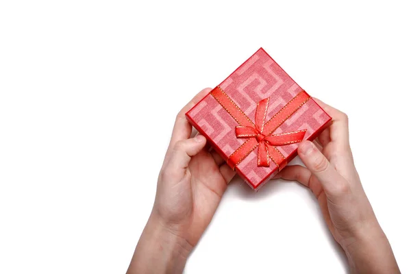 Manos de bebé sosteniendo una caja de regalo roja aislada sobre un fondo blanco — Foto de Stock