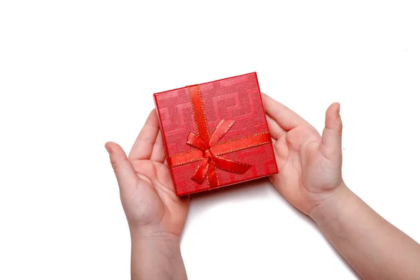 Manos de bebé sosteniendo una caja de regalo roja aislada sobre un fondo blanco — Foto de Stock